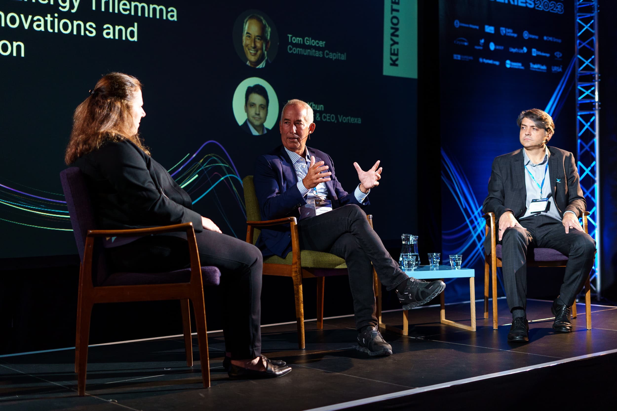 Speaker presenting on stage with Vortexa branding at London 2023 event.